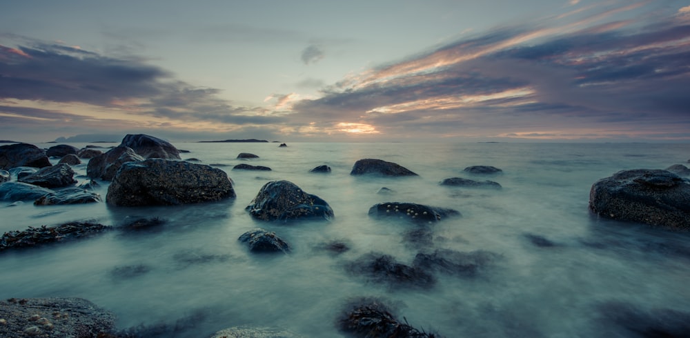 Olas del océano rompiendo contra las rocas durante la puesta de sol