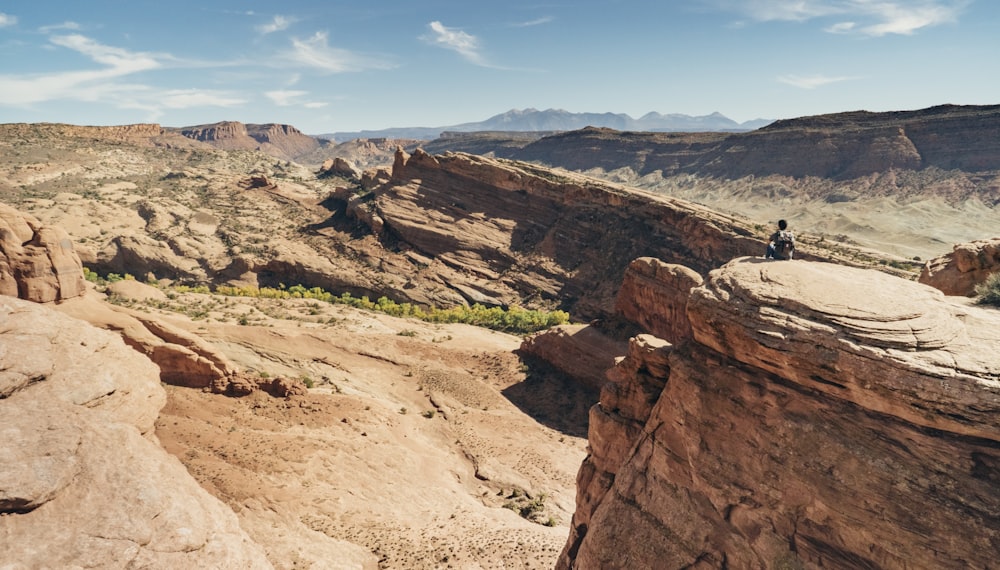 person sitting on brown mountain