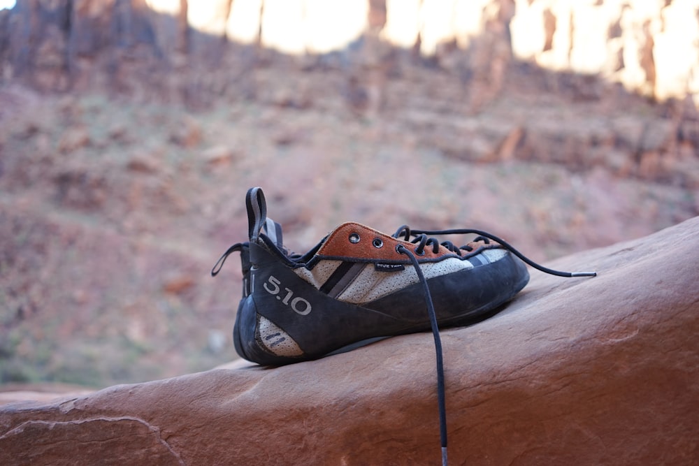 black and white shoes place on rock formation