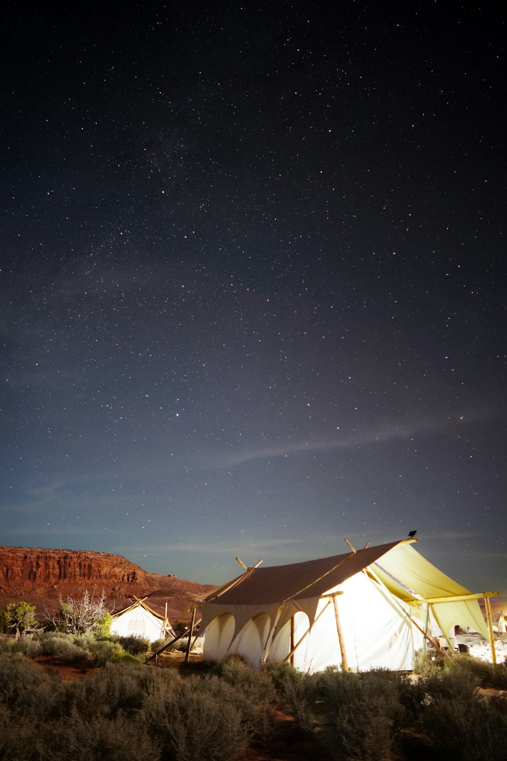 야간에 열린 들판에 흰색 오두막 텐트