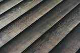 Wooden planks laid out in a parallel arrangement, displaying a textured surface with natural grain patterns.
