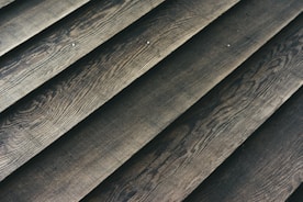 Wooden planks laid out in a parallel arrangement, displaying a textured surface with natural grain patterns.