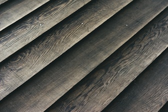 Wooden planks laid out in a parallel arrangement, displaying a textured surface with natural grain patterns.