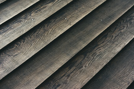 Wooden planks laid out in a parallel arrangement, displaying a textured surface with natural grain patterns.