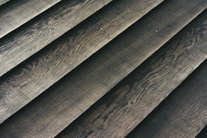 Wooden planks laid out in a parallel arrangement, displaying a textured surface with natural grain patterns.
