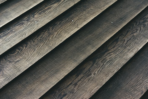 Wooden planks laid out in a parallel arrangement, displaying a textured surface with natural grain patterns.