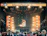 A vibrant outdoor festival stage with colorful lighting and a lively crowd enjoying the event.