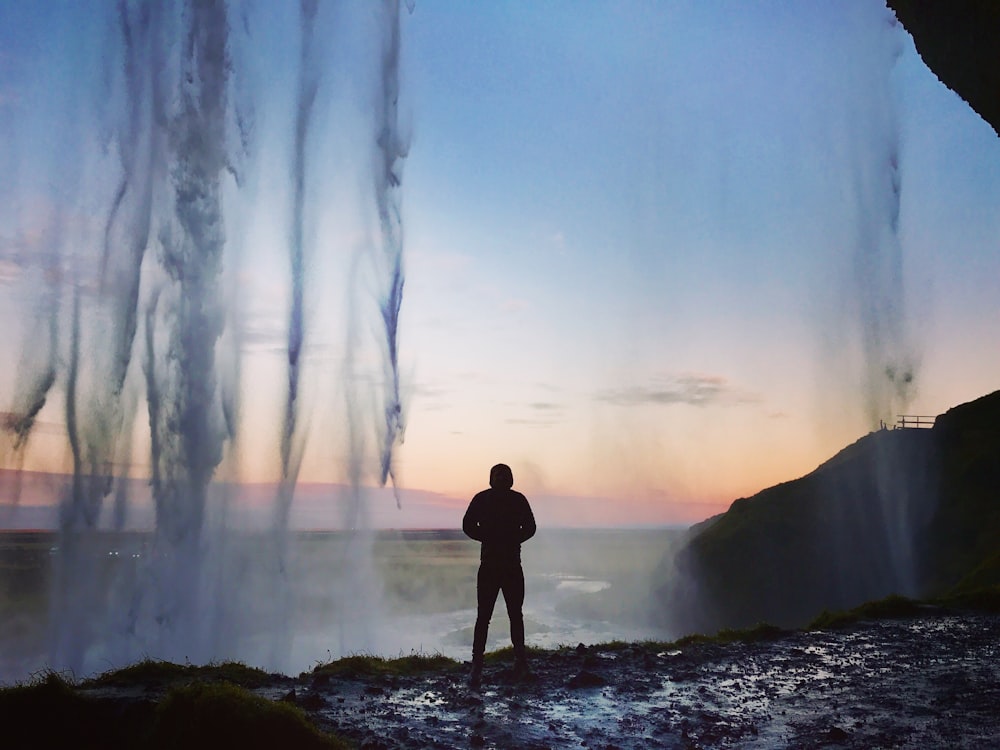 silhouette sur l’homme debout près du plan d’eau