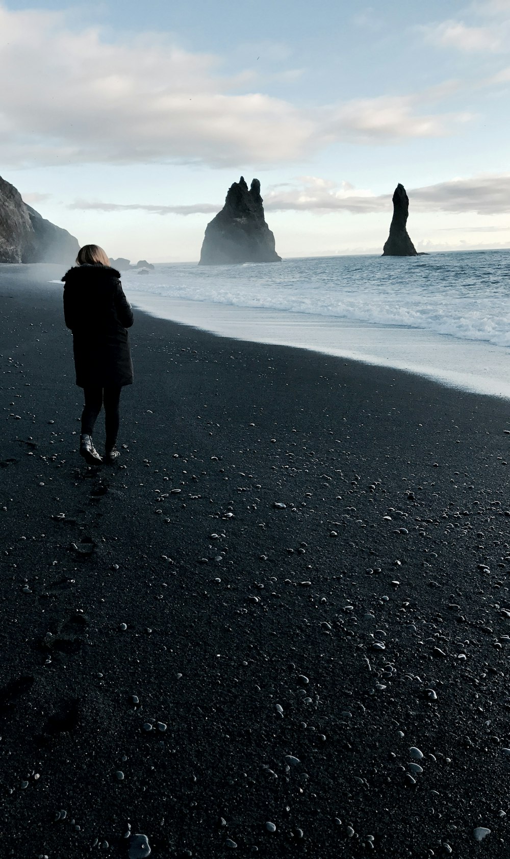 persona che cammina vicino allo specchio d'acqua