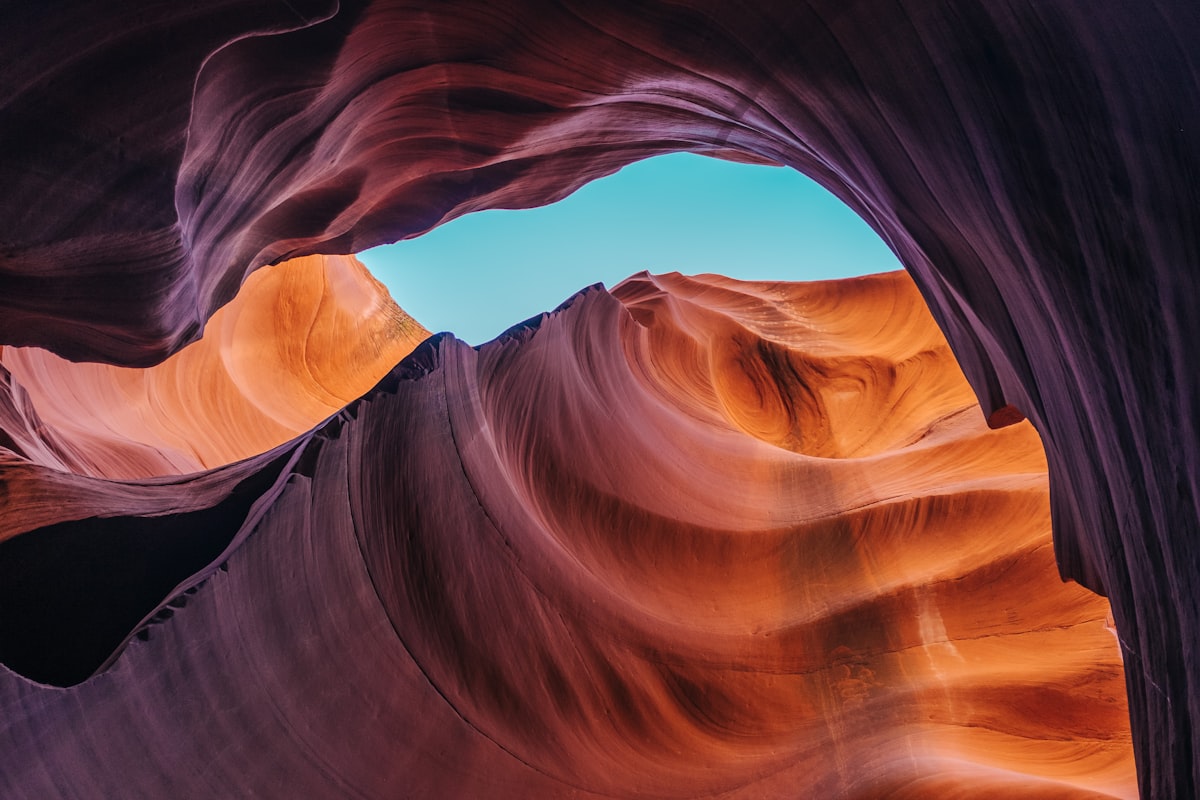 A photo of a blue sky opening up from within a red canyon.