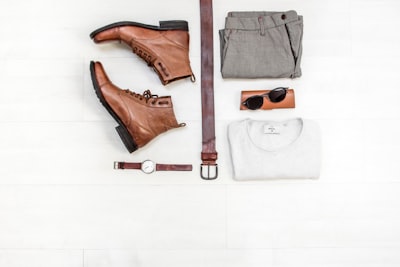 pair of brown leather boots beside bet sunglass zoom background