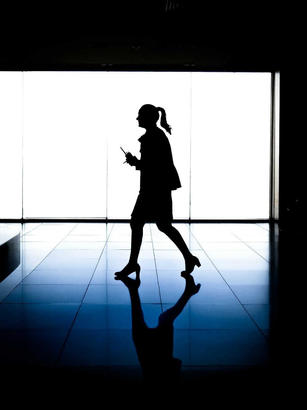 silhouette of woman walking inside building