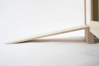 A sturdy door blocker installed on a modern wooden door with soft pink sakura accents.