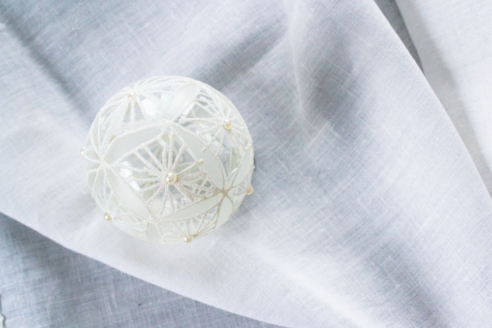 white lace Christmas bauble on white garment