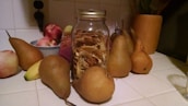 A cozy kitchen scene with jars of dried fruits and nuts neatly arranged on wooden shelves.