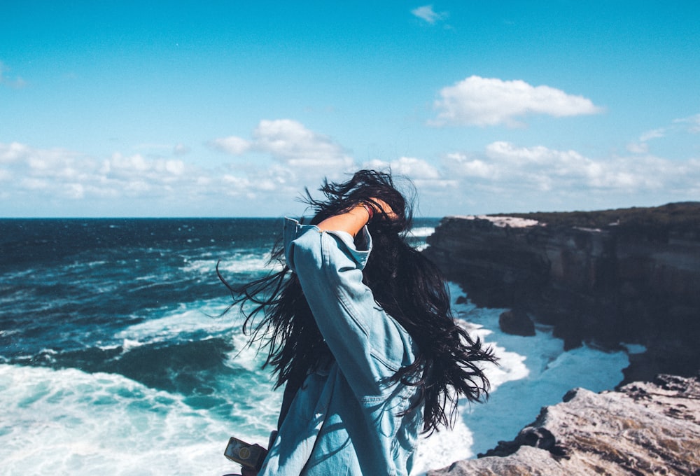 person standing in front of body of water during daytime