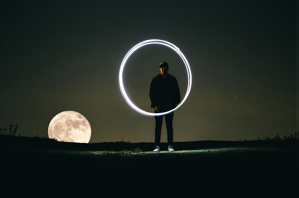 man standing on hill during full moon
