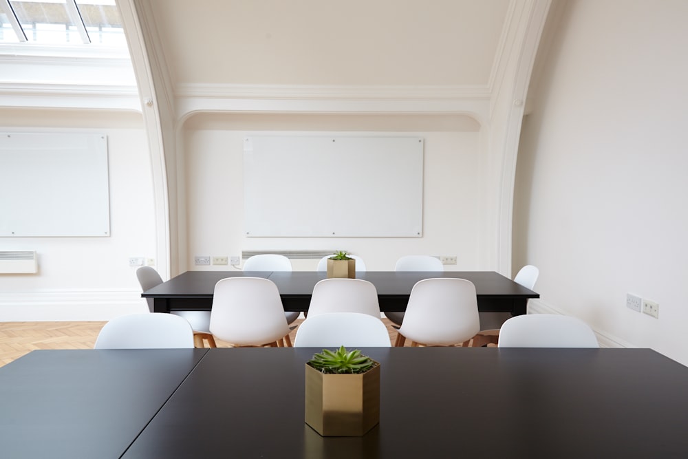 An elegant conference room with two whiteboards, black tables and white chairs