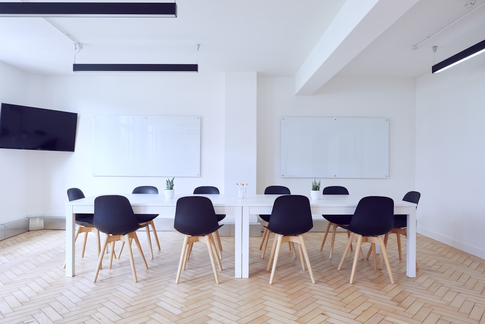 A bright conference room with two whiteboards and a television