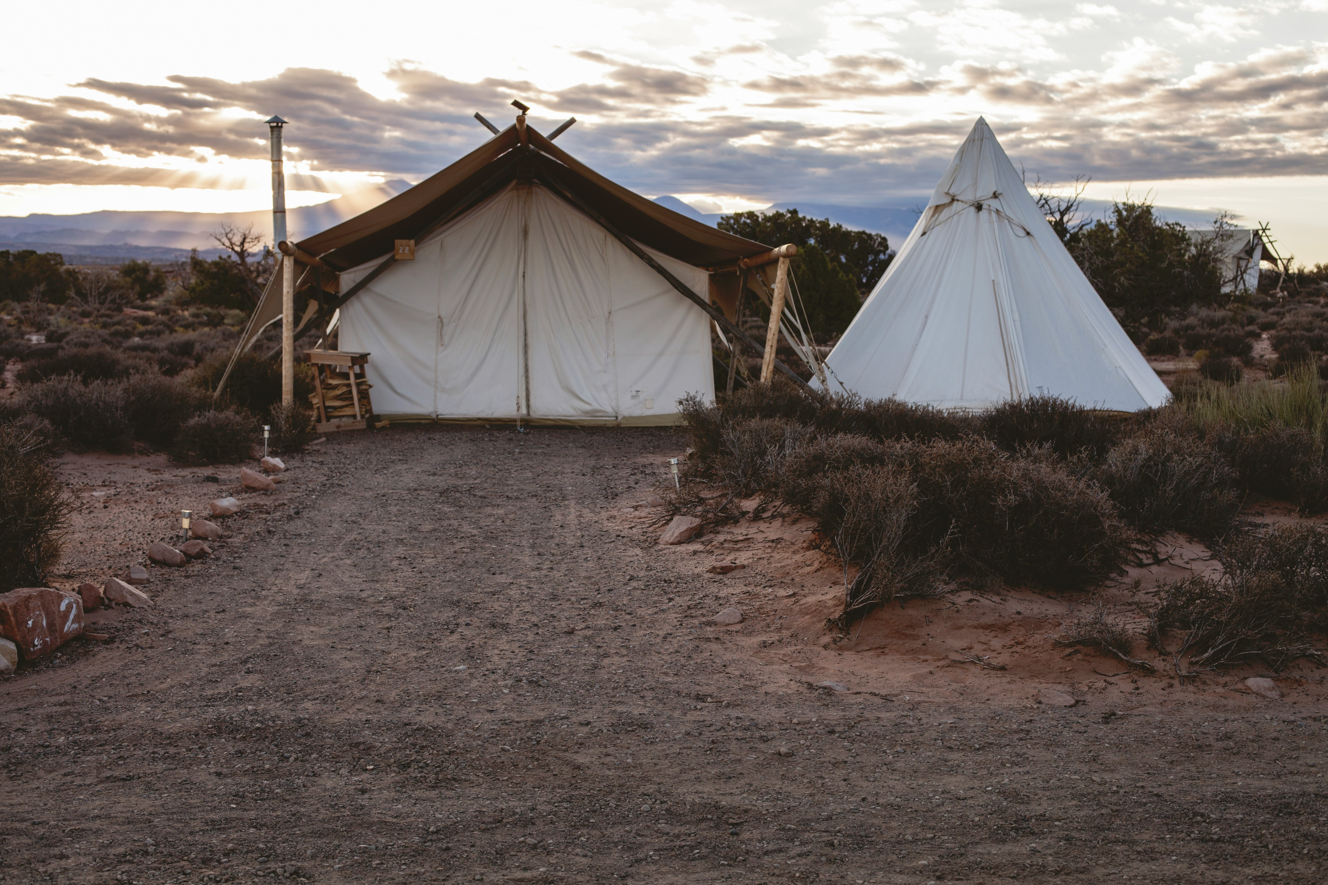 white tipi tent surrounded by grass