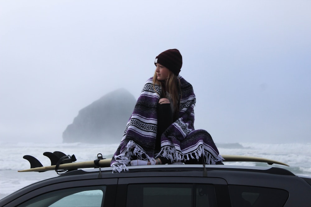 woman wearing beanie hat on vehicle roof
