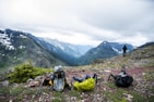 A scenic view showcasing hiking supplies against a mountainous backdrop.