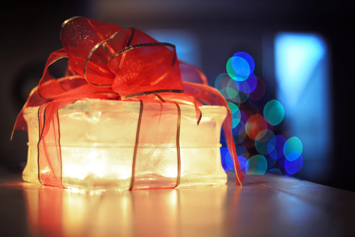 Een cadeau met rood lint, verlicht van binnenuit