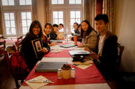 Cheerful students enjoying a hands-on hospitality workshop with real table settings.