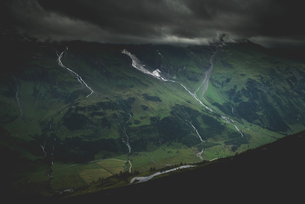 Montagne verte sous un ciel nuageux sombre