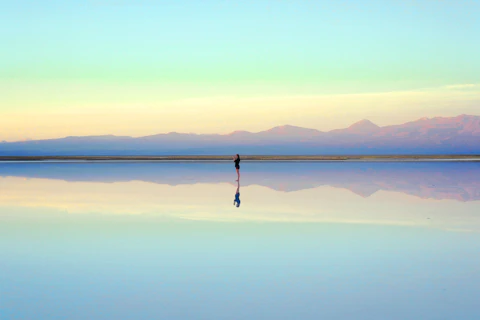 Persona sola ante un paisaje tranquilo y reflectante