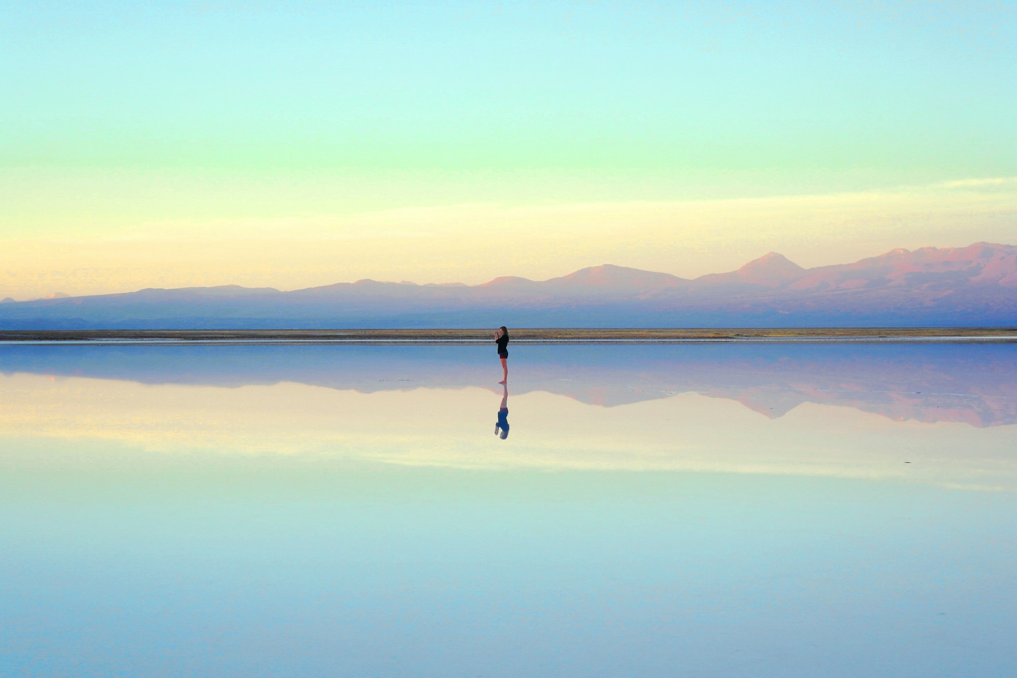 Woman taking a picture in the middle of a "salar"/lake in the dessert of Atacama, Chile.