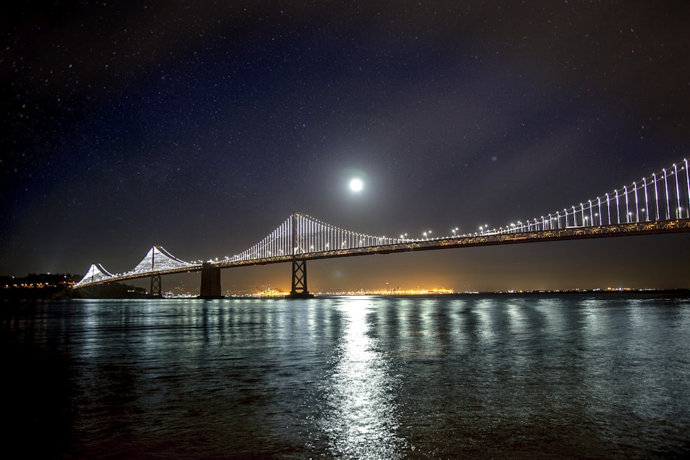 サンフランシスコとオークランド湾の吊り橋に浮かぶ月が水面に映る