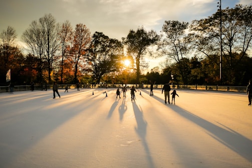 A lively group of children and adults skating together in a sunny outdoor rink in Hasharon.