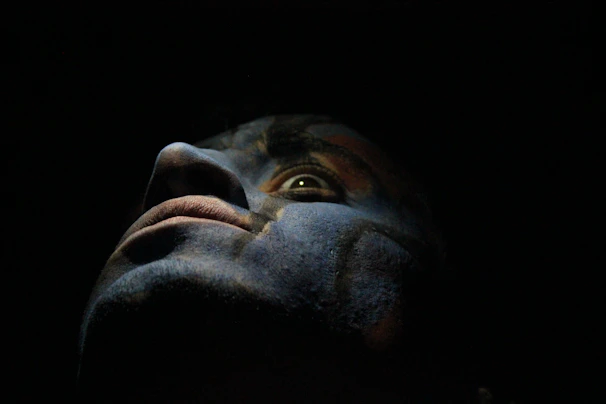 Close-up of a figure’s face showing expressive features and meticulous paintwork under soft lighting.