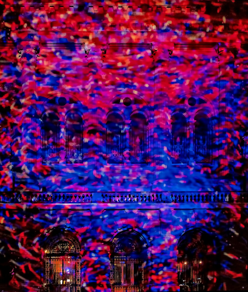 Holofotes vermelhos e azuis brilhando vividamente em um edifício.
