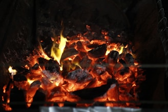 A warm, glowing ember scene with soft gold light and faint smoke.