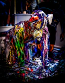 Spray artist mid-action, surrounded by a mist of red and yellow paint with small skulls drifting behind.