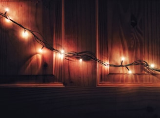 A delicate string of fairy lights twinkling above a rustic wooden bench.