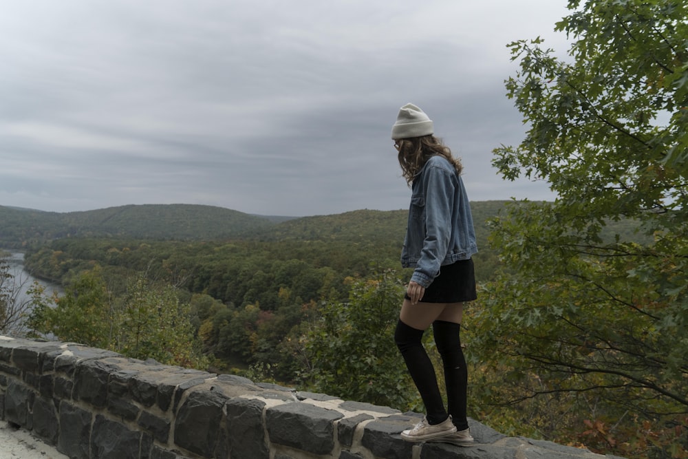 woman standing on rock wall