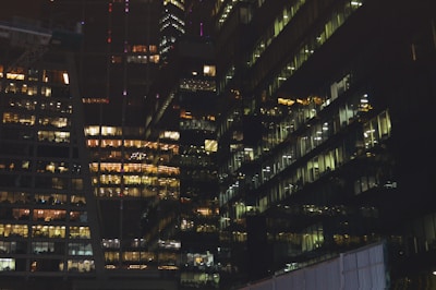 Nighttime cityscape showcasing illuminated office buildings.