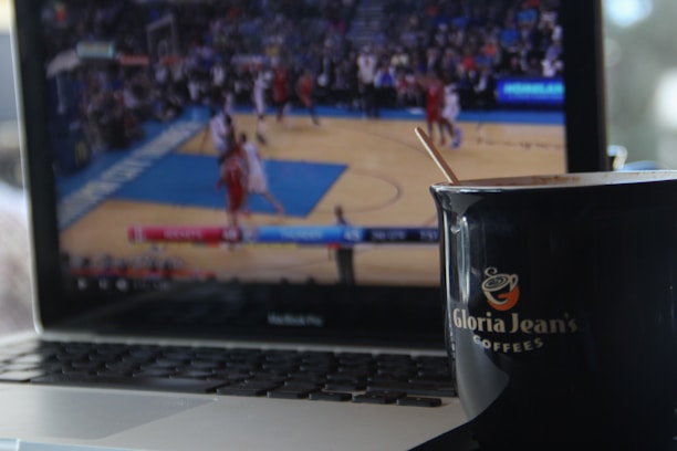 A close-up of a laptop screen displaying a vibrant sports score update page.