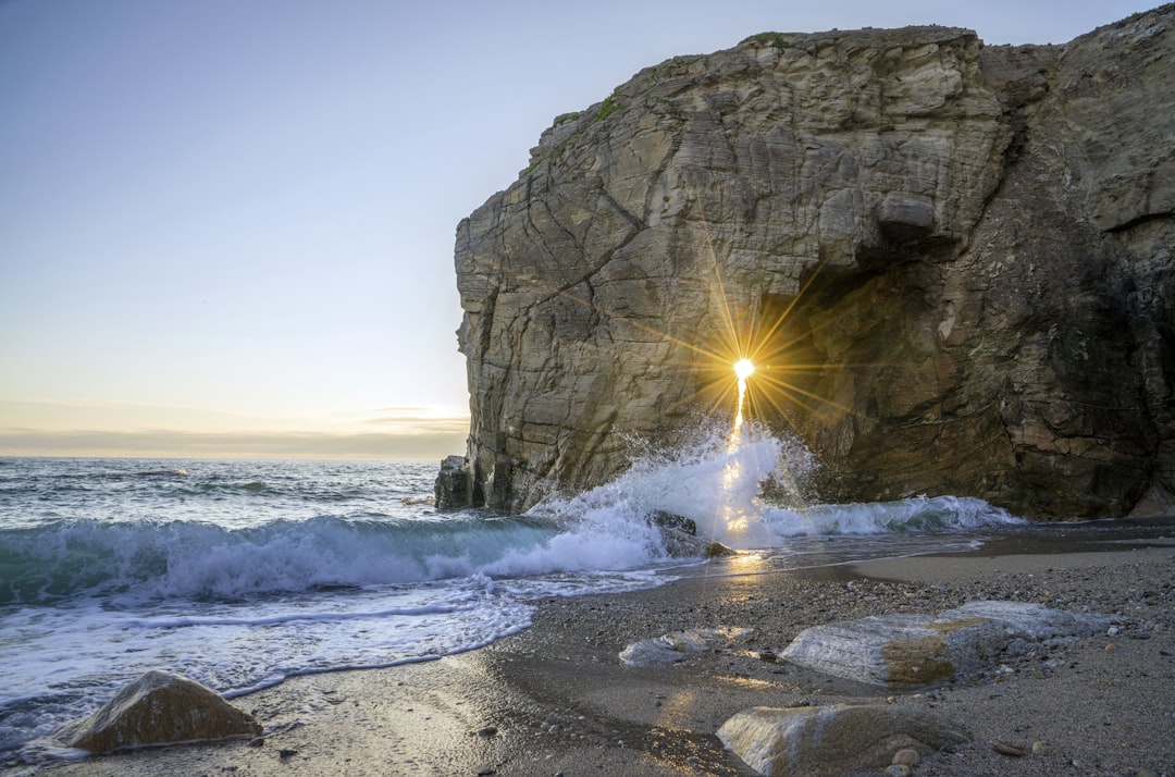 sea wave splashing in seashore beside mountain, Cote Sauvage at sunet.
