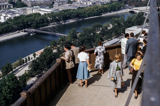 people standing on terrace with view of river in Eiffel Tower France