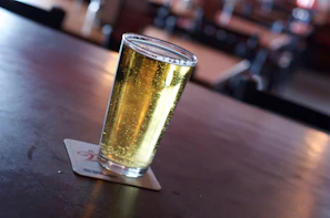 Golden Pilsen do Verão poured into a glass, highlighting its clear color and light foam on a wooden table