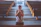 An intimate shot of a man praying quietly in a sunlit church with rustic wooden beams.