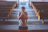 An intimate shot of a man praying quietly in a sunlit church with rustic wooden beams.