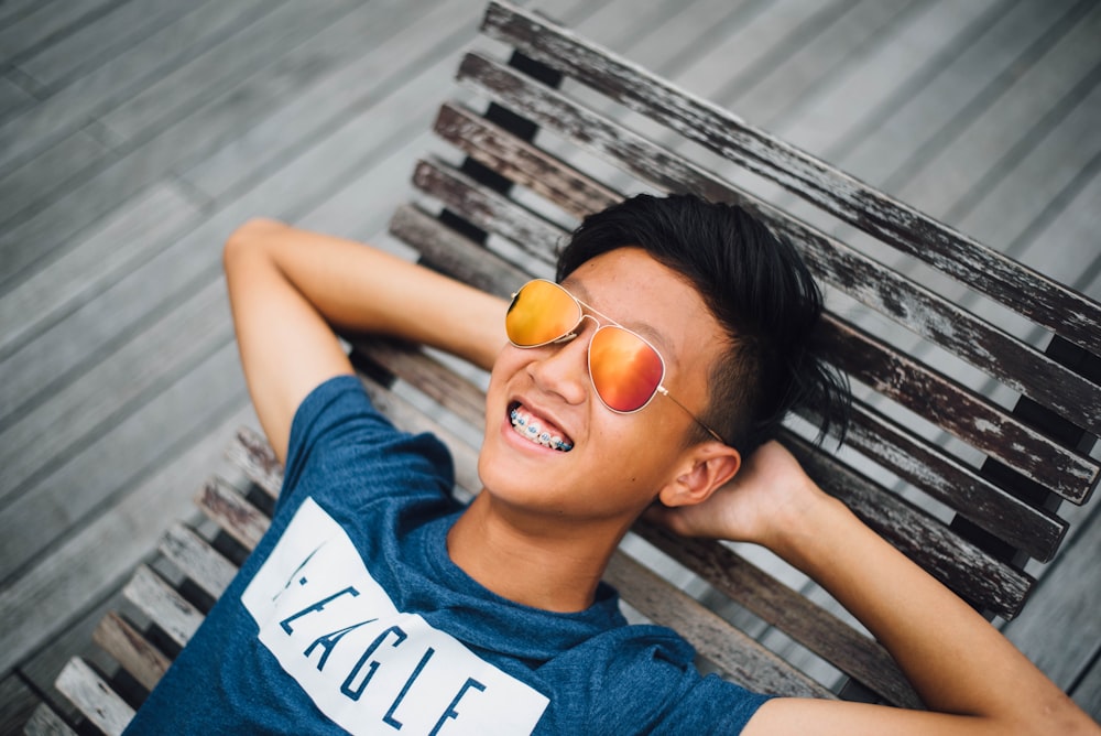 smiling boy lying on lounger wearing sunglasses