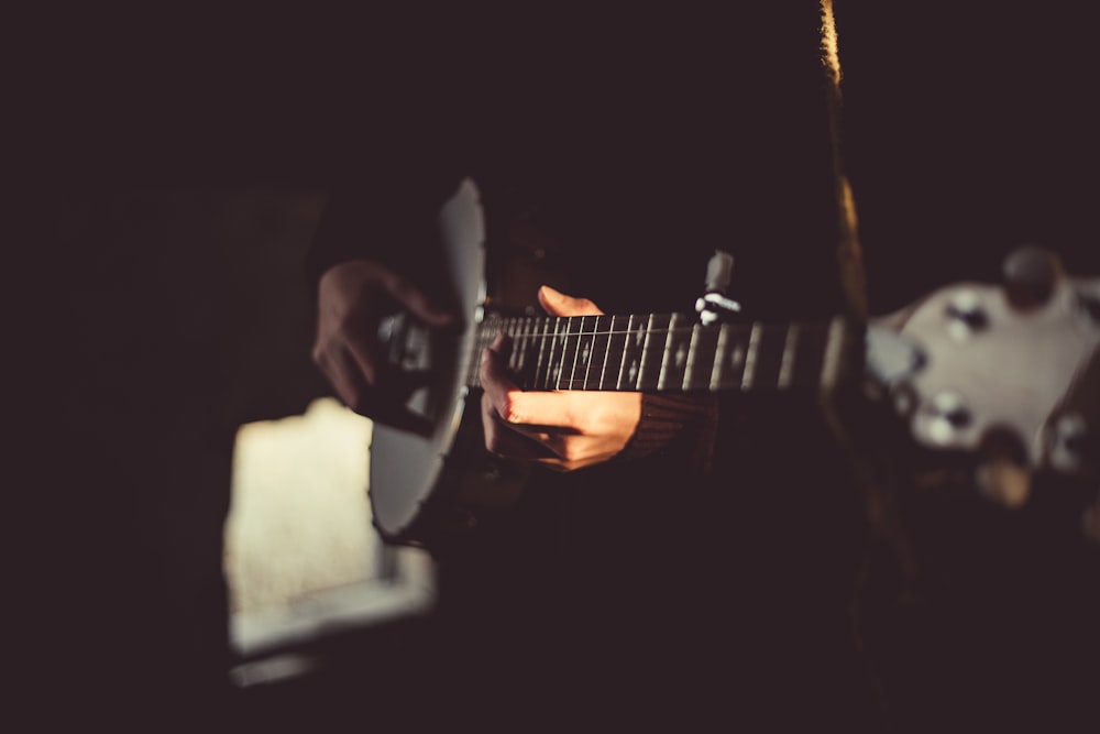 person playing banjo inside dark room