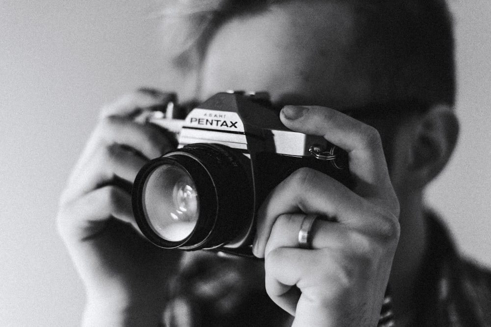 grayscale photo of man taking photo