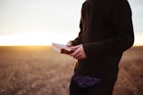 man holding book in the ricefield